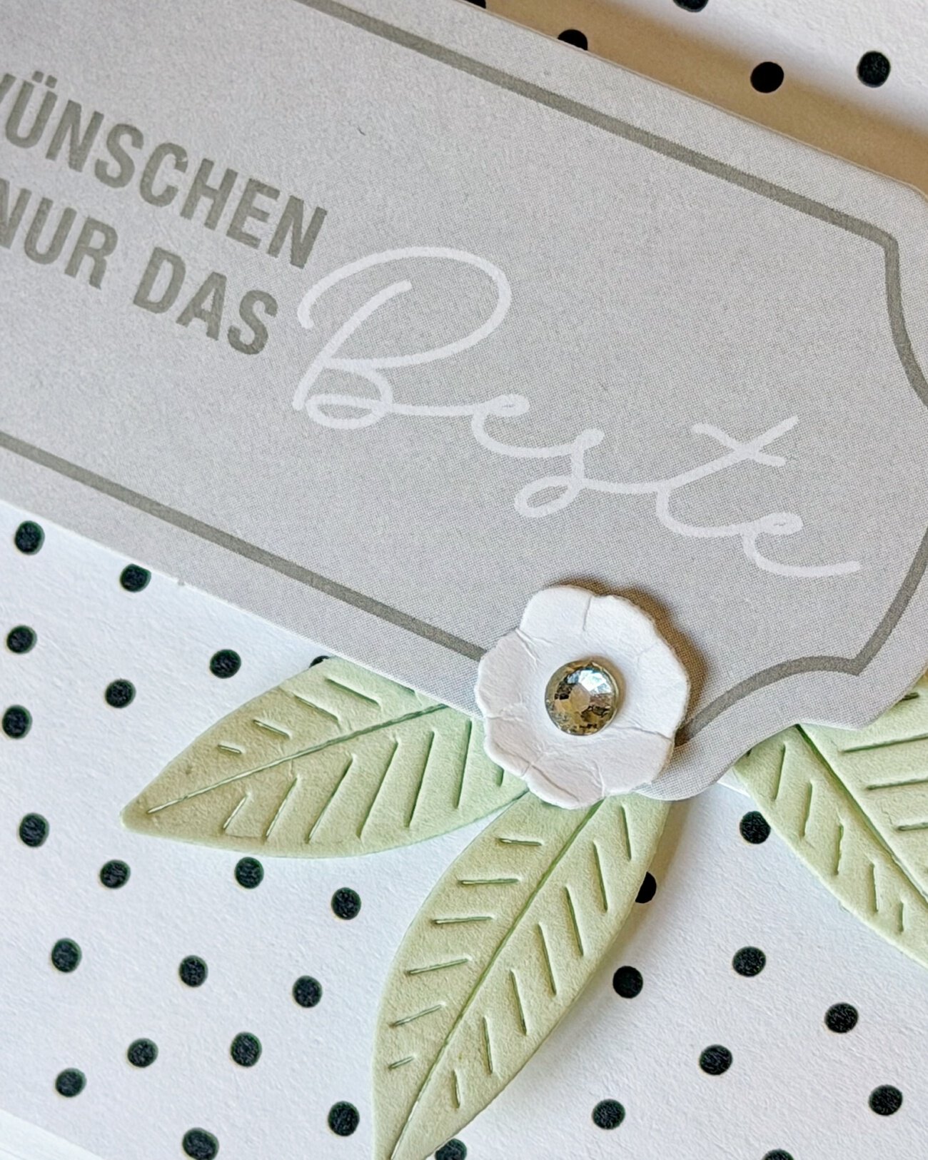 Detail der Banderole mit Spruch-Etikett, Blaettern und Glitzerstein