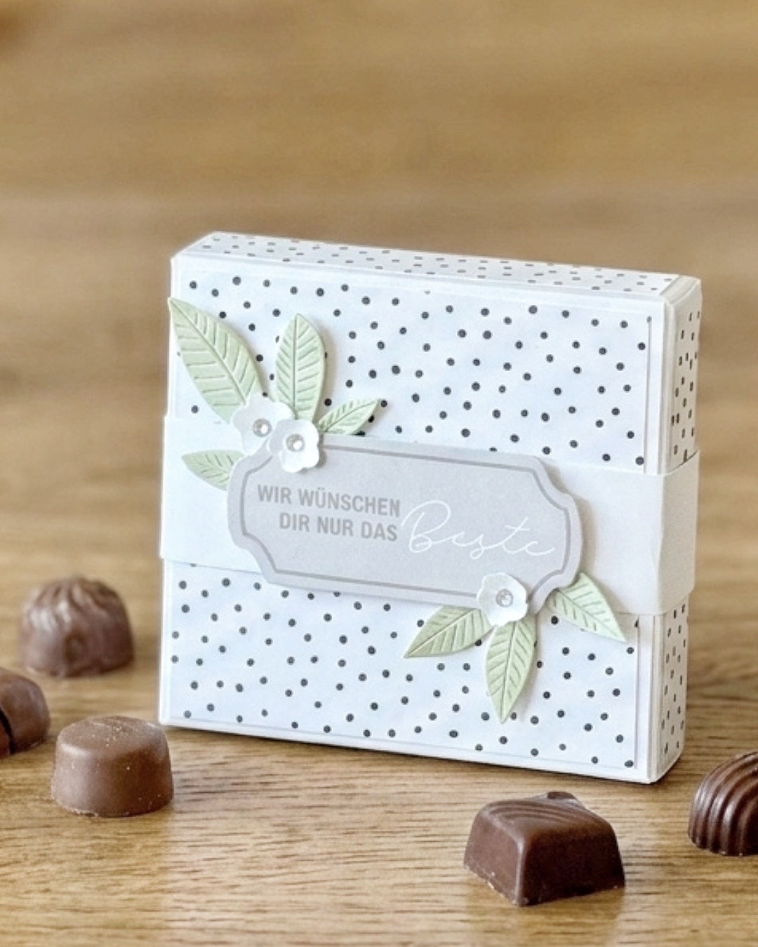 Kleine selbst schliessende Verpackung mit Banderole, Spruch-Etikett und Pralinen