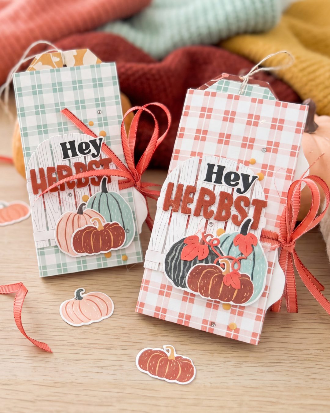 Zwei fertige Mini-Alben „Hey Herbst“ in Aquamarin- und Calypso-Karo mit weißem Gartentor, Kürbissen und Schleife auf einem Holztisch